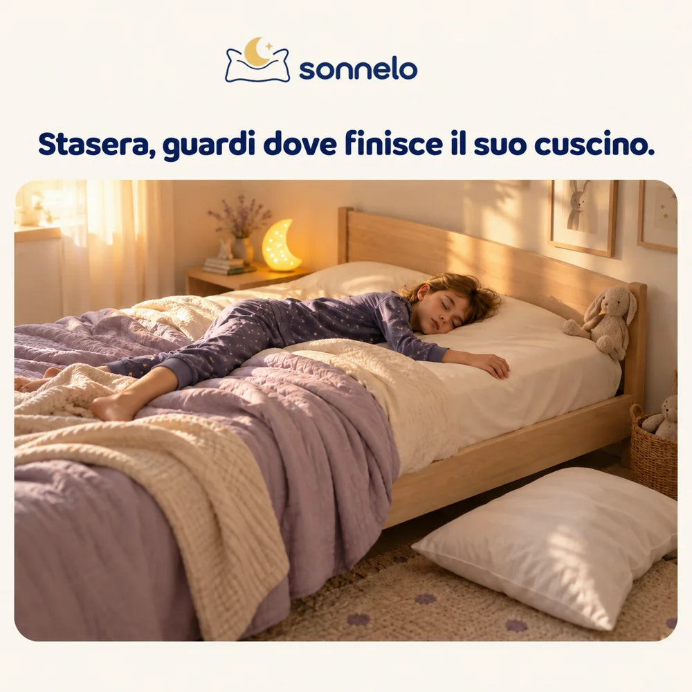Bambino addormentato di traverso, cuscino caduto per terra
